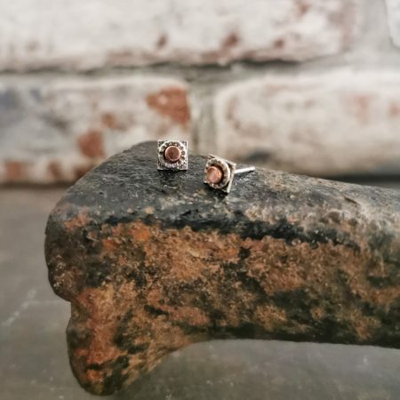 stud earrings sitting on a cobblers last