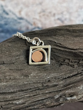 necklace displayed on bog oak- handmade sunrise necklace