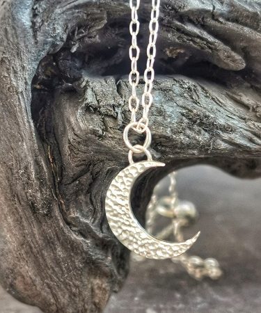 necklace hanging infront of bog oak - sterling silve moon necklace